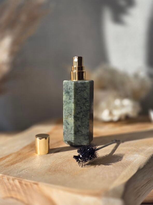 Bouteille de parfum en jade vert, pierre de guérison et aromathérapie pour relaxation et bien-être.