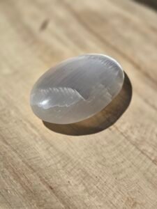 Galet de sélénite blanche de 7 cm utilisé pour la purification énergétique, la méditation et l’harmonisation des lieux.