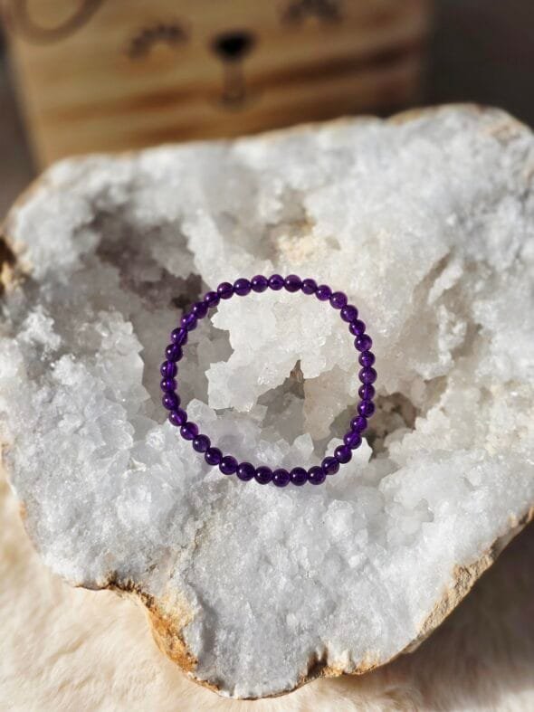 Bracelet Améthyste 4 mm pour enfant posé sur une géode