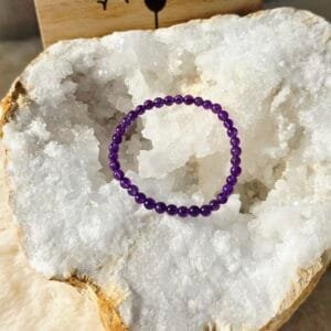 Bracelet Améthyste 4 mm pour enfant posé sur une géode