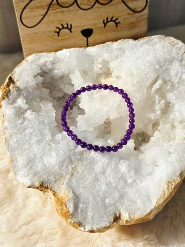 Bracelet Améthyste 4 mm pour enfant posé sur une géode