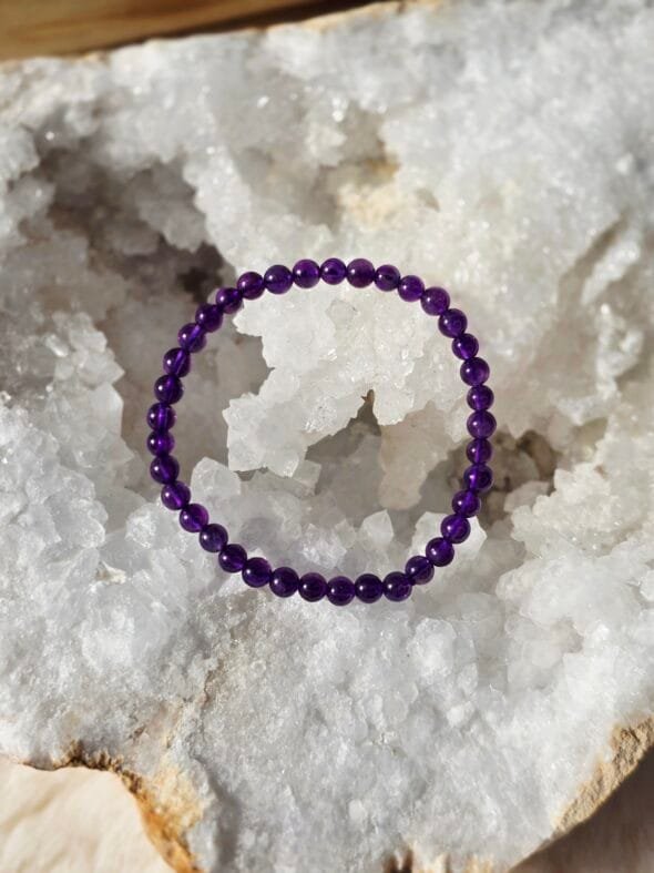 Bracelet Améthyste 4 mm pour enfant posé sur une géode