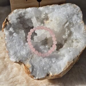 Bracelet quartz rose 6 mm pour enfant posé sur une géode