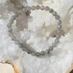 Bracelet en labradorite naturelle 6 mm posé sur une géode de quartz