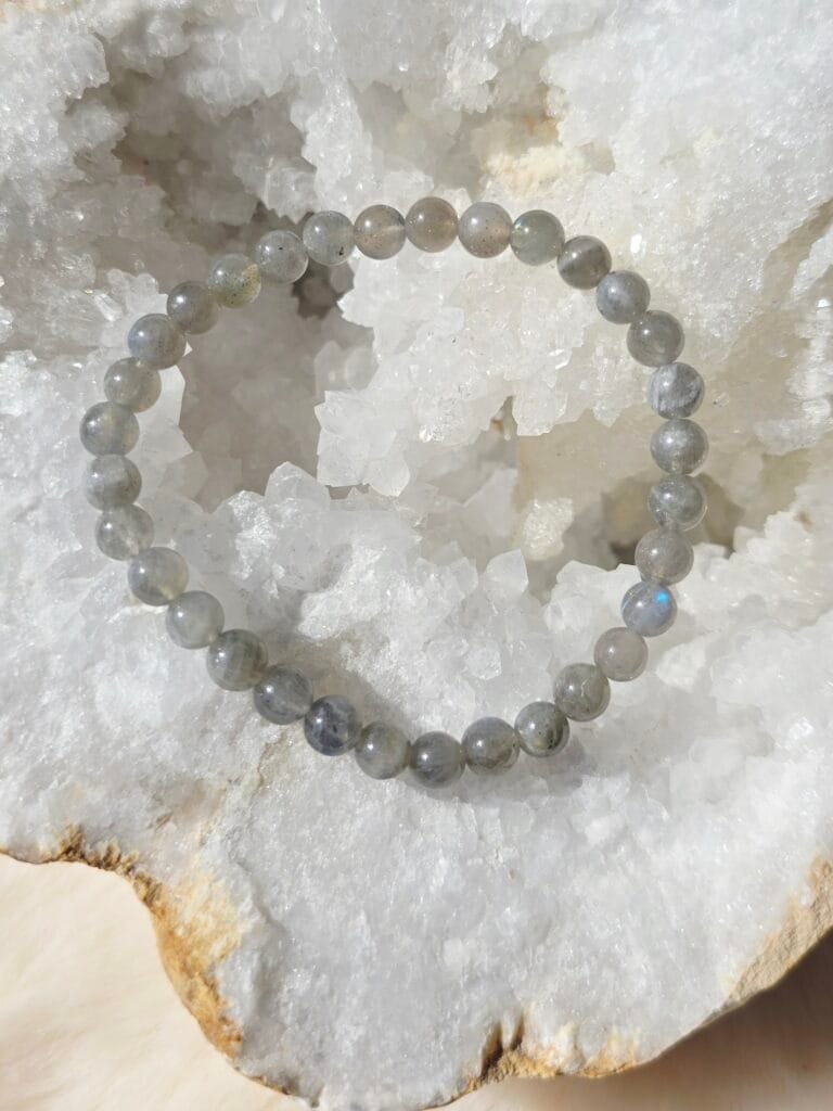 Bracelet en labradorite naturelle 6 mm posé sur une géode de quartz