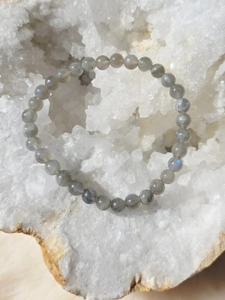Bracelet en labradorite naturelle 6 mm posé sur une géode de quartz