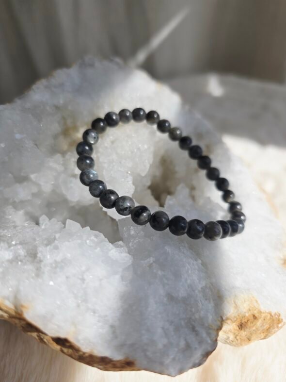Bracelet en larvikite naturelle 6 mm posé sur une géode de quartz