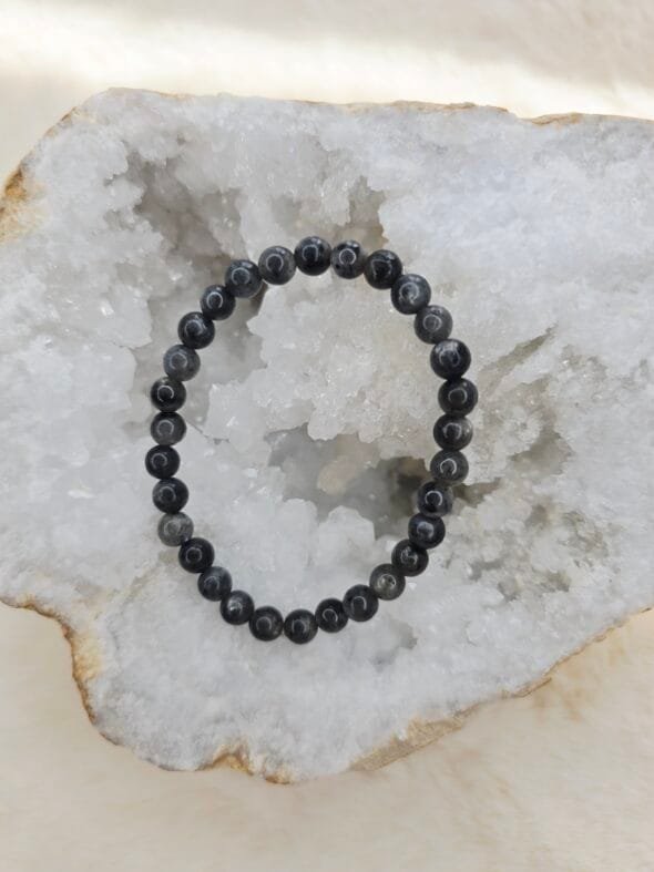Bracelet en larvikite naturelle 6 mm posé sur une géode de quartz