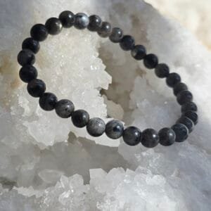 Bracelet en larvikite naturelle 6 mm posé sur une géode de quartz