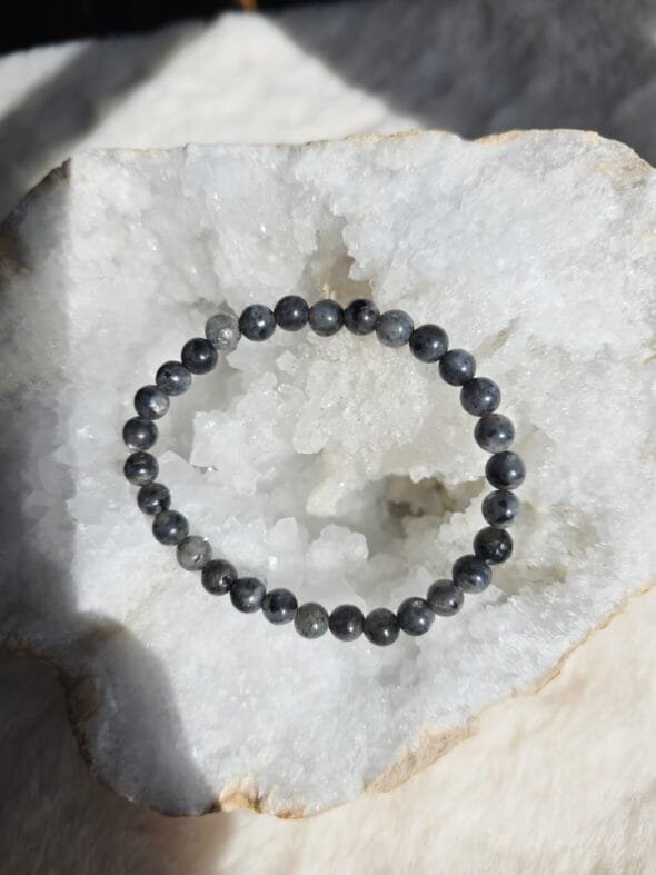 Bracelet en larvikite naturelle 6 mm posé sur une géode de quartz