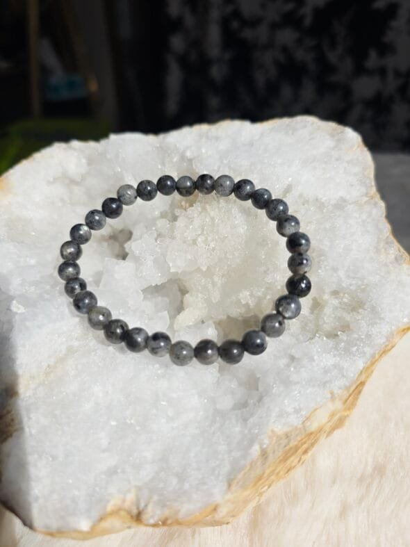 Bracelet en larvikite naturelle 6 mm posé sur une géode de quartz