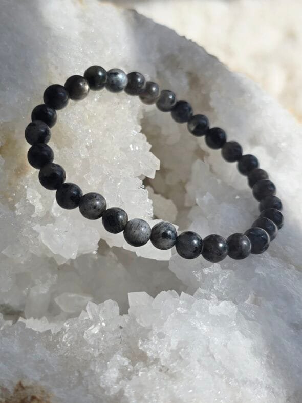 Bracelet en larvikite naturelle 6 mm posé sur une géode de quartz