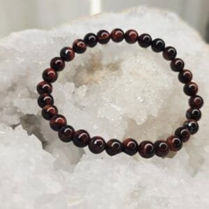 Bracelet en perles naturelles d’Œil de Taureau 6 mm posé sur géode quartz