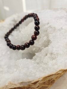 Bracelet en perles naturelles d’Œil de Taureau 6 mm posé sur géode quartz