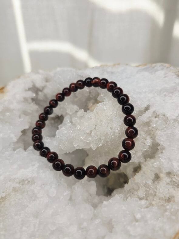Bracelet en perles naturelles d’Œil de Taureau 6 mm posé sur géode quartz