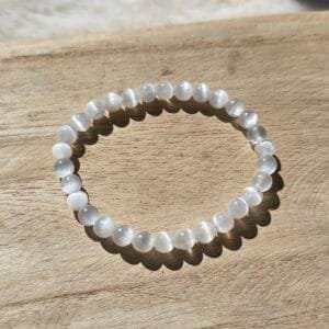 Bracelet en perles naturelles de sélénite blanche, diamètre 6 mm, posé sur une surface claire.