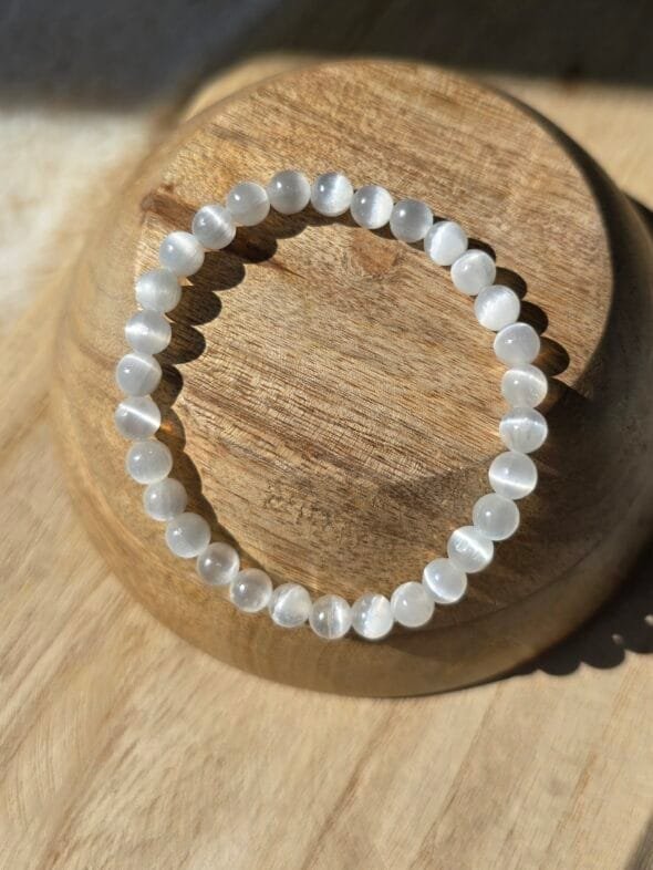 Bracelet en perles naturelles de sélénite blanche, diamètre 6 mm, posé sur une surface claire.