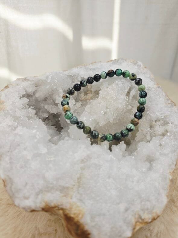 Bracelet en perles naturelles de Variscite 6 mm posé sur une géode de quartz