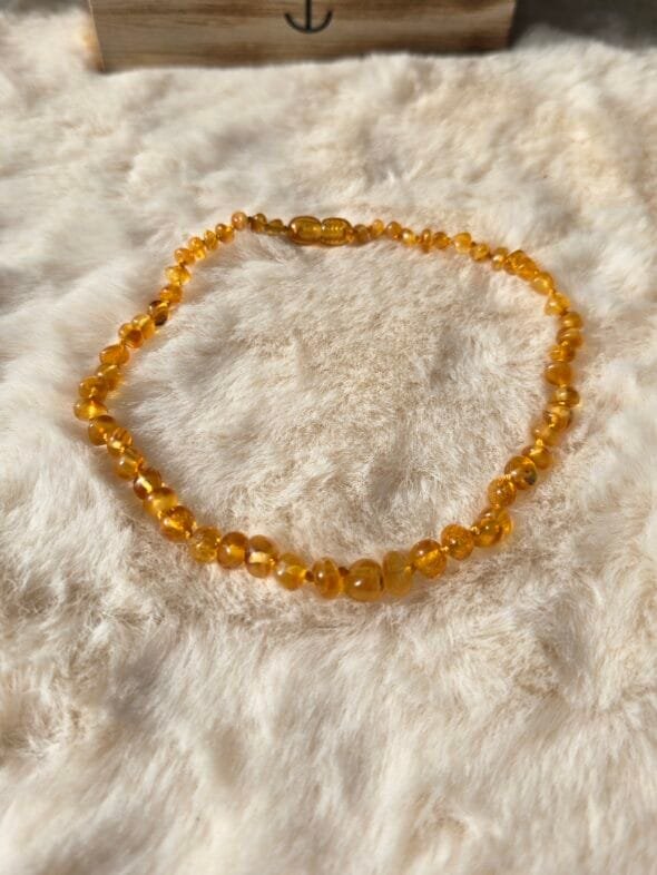 Collier bébé Ambre Miel AA sur fond neutre