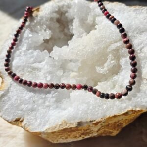 Collier en rhodonite naturelle 4 mm posé sur une géode