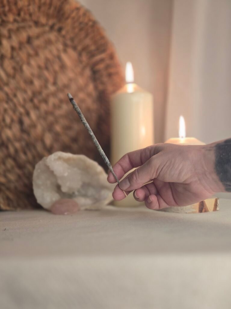 main tenant un bâton d'encens allumé en préparation d'un rituel avec Isha Kriya