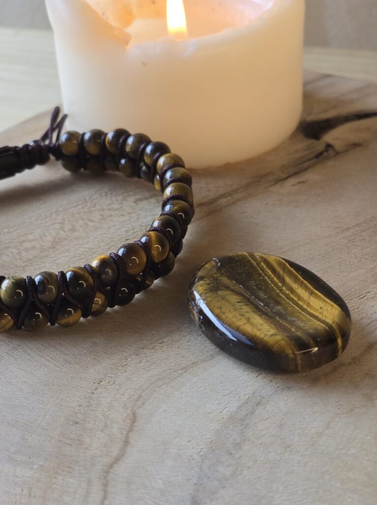 Pierre de souci et bracelet homme en œil de tigre sur bois avec bougie pour protection et courage