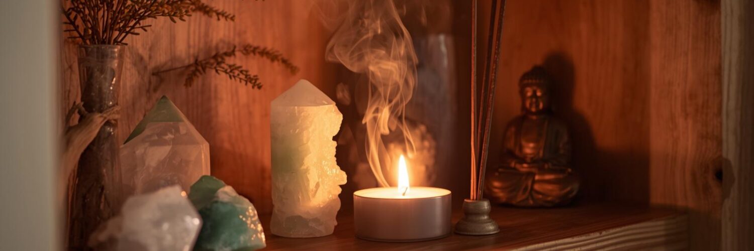 Créer un autel de cristaux à la maison — espace sacré cocooning Autel de cristaux sur étagère avec bougie, encens et bouddha — ambiance cocooning Isha Kriya