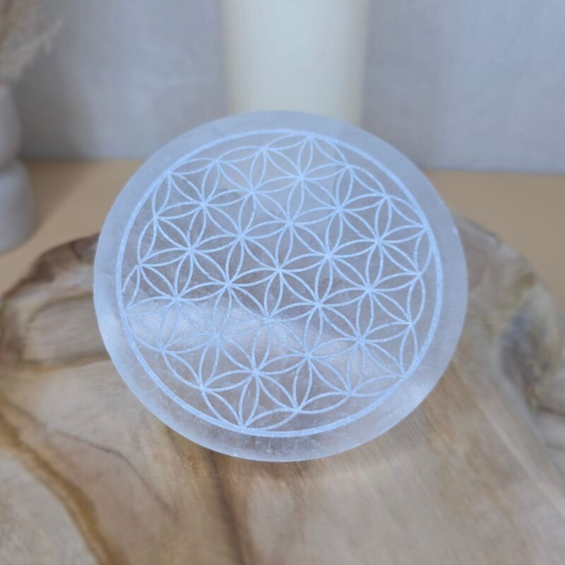 Plaque en sélénite blanche gravée du symbole sacré de la Fleur de Vie, utilisée pour la purification et le rechargement des pierres.